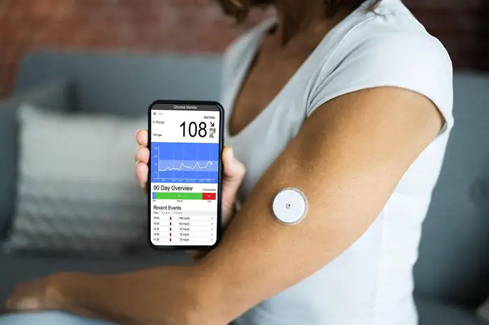 Sensor de glicose no braço e o aplicativo de leitura no celular